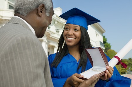 Father Giving Daughter Graduation Giftの写真素材