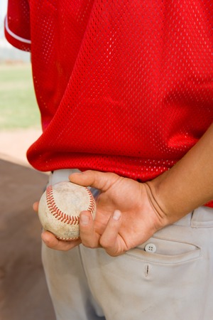 Pitcher Holding Baseball Behind His Backの写真素材