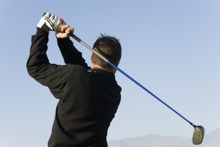 Man Swinging Golf Clubの写真素材
