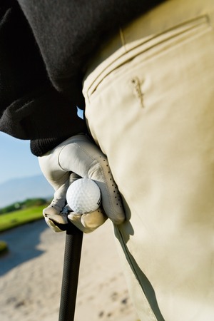 Hand Holding Golf Ball and Clubの写真素材