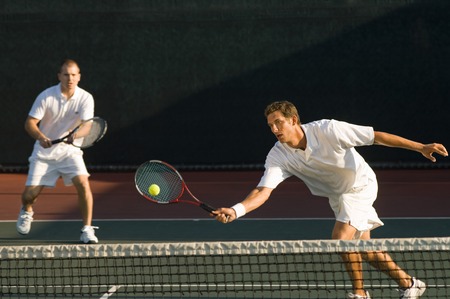 Tennis Player Swinging at Ballの写真素材