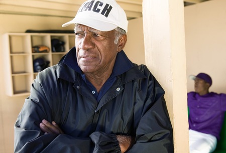 Baseball Coach Standing in Dugoutの写真素材