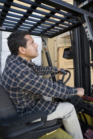 Mid-adult man driving forklift truckの写真素材