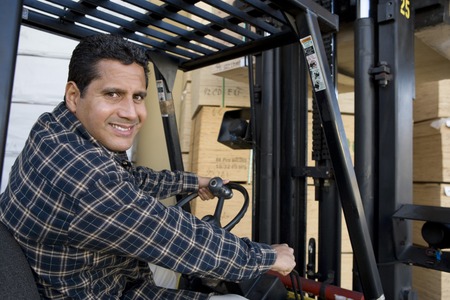 Mid-adult man driving forklift truckの写真素材