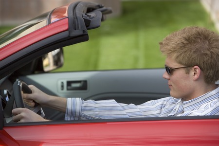 Young man driving convertible car