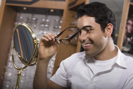 Man trying on eyeglasses in store