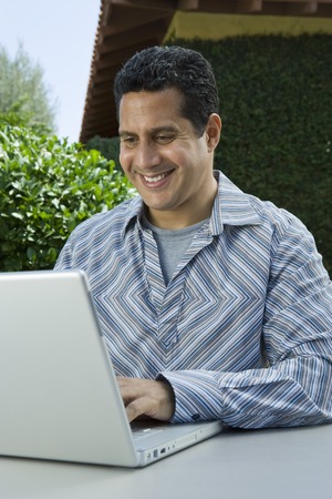 Man using laptop in back yard