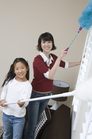 Woman and girl (10-12) doing houseworkの写真素材