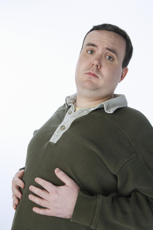 Overweight mid-adult man with hands on his bellyの写真素材