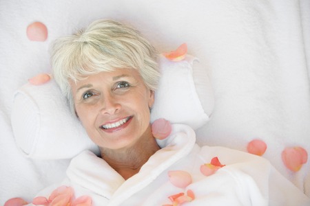 Woman Relaxing at the Spa Surrounded by Rose Petalsの写真素材