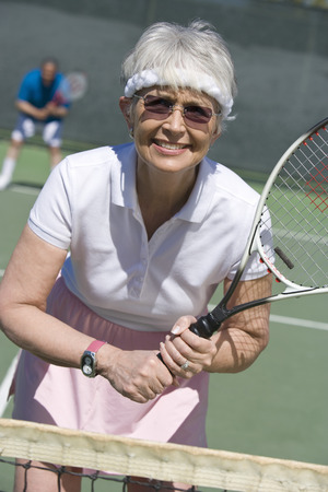 Senior woman playing tennis, portraitの写真素材
