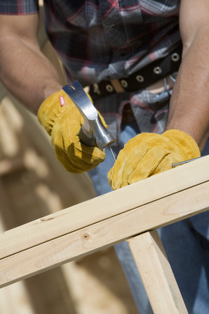 Construction worker using hammer, close-upの写真素材