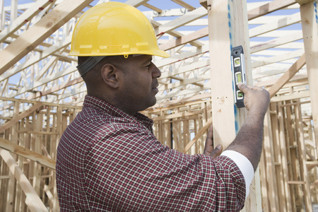 Construction worker using spirit level on buildingの写真素材
