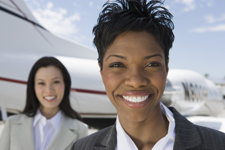 Portrait of mid-adult businesswoman standing in front of private plane.の写真素材