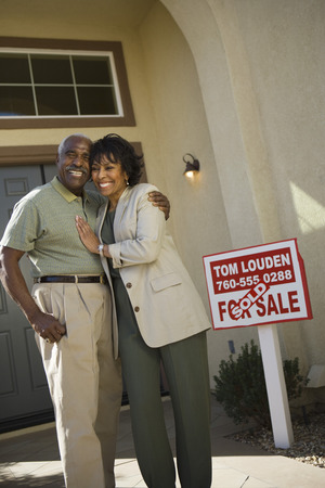 Middle-aged couple in front of new homeの写真素材