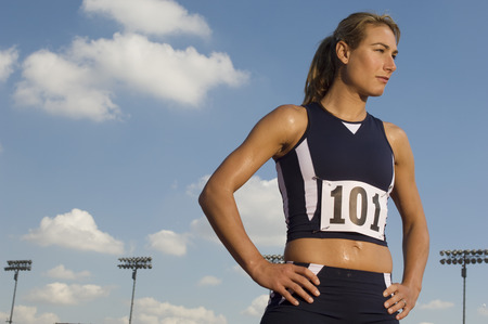 Female track athlete standing on trackの写真素材