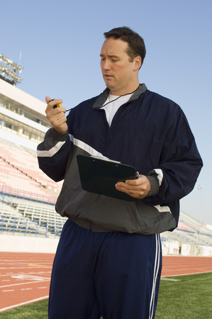 Sports coach looking at stopwatchの写真素材