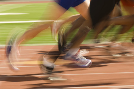 Low section of runners running on a trackの写真素材