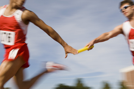 Athletes passing relay batonの写真素材