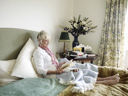 Senior Woman Relaxing with a Bookの写真素材