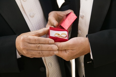 Groom and father holding wedding rings (close-up)