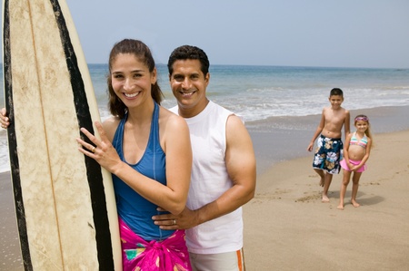 Family with Surfboard on Beachの写真素材