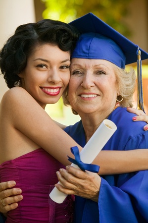 Senior graduate hugging granddaughter outsideの写真素材