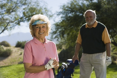 Senior couple in golf course smiling focus on woman (portrait)の写真素材