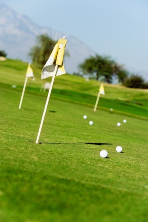 Golf course green with flags and ballsの写真素材