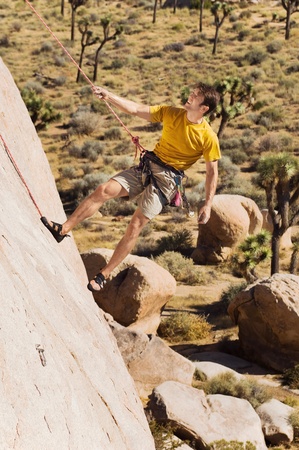 Climber Tugging on Rope on Cliffの写真素材