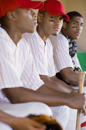 Baseball players sitting in dugout