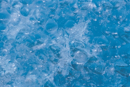 Water bubbling under ice close up