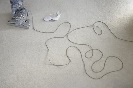 Cord vacuum cleaner and shoes laying on carpetの写真素材