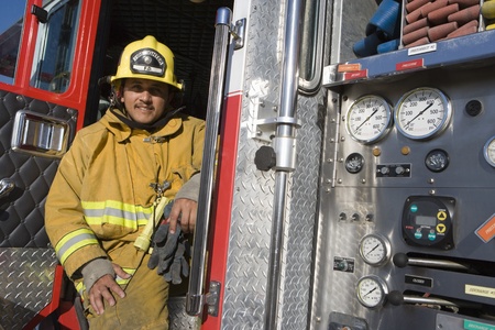 Firefighter sits on fire engine