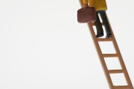 Businessman figurine climbing ladder low sectionの写真素材