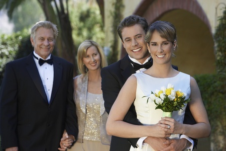 Bride and groom with parents in background portraitの写真素材