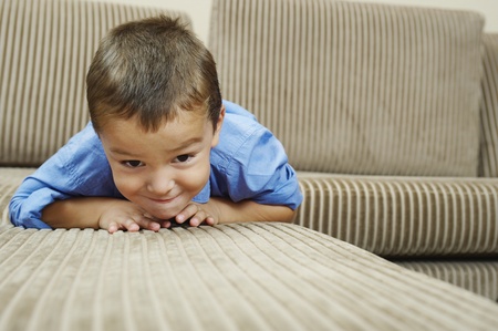 Boy relaxing on sofa in living roomの写真素材