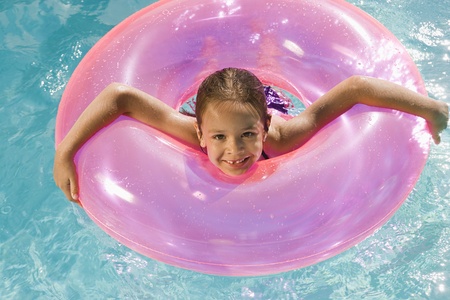 Girl Inside Pink Float Tube in Poolの写真素材
