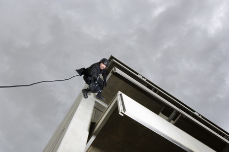 SWAT Team Officer Rappelling and Aiming Gunの写真素材