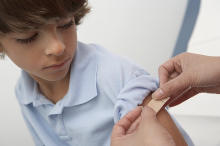 Nurse placing bandage on boy's armclose upの写真素材