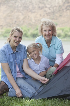 Mother daughter and grand-daughter putting up a tent