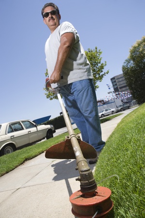Portrait of man cutting grass