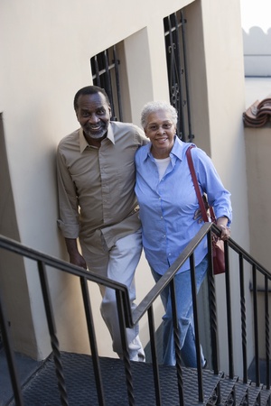 Portrait of senior couple walking up steps smilingの写真素材