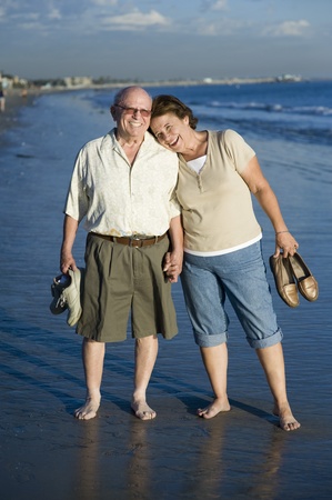 Senior couple standing on beach portraitの写真素材