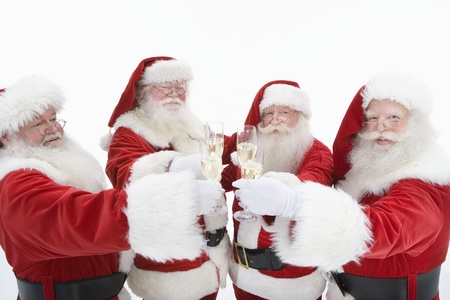 Group of men dressed as Santa Claus toasting champagne