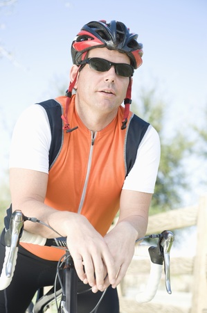 Male cyclist leans on handlebarsの写真素材