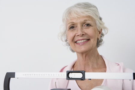 Senior woman stands on hospital scales