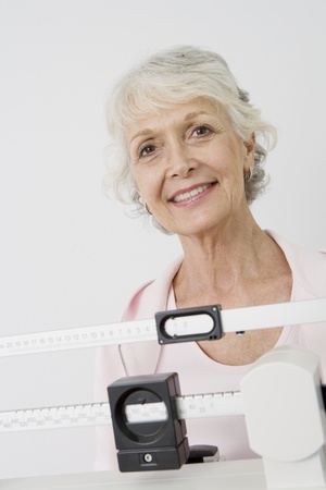Senior woman stands on hospital scalesの写真素材