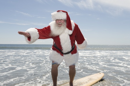 Father Christmas surfboards at the waters edgeの写真素材