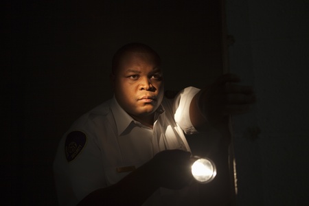Security guard investigates with flashlightの写真素材